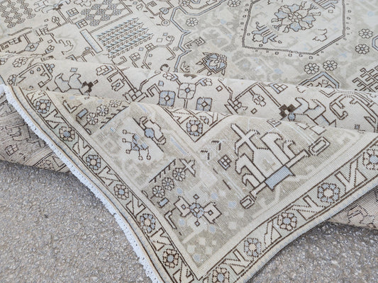 Folded corner of a beige Turkish wool-cotton rug showing brown geometric motifs and the underside